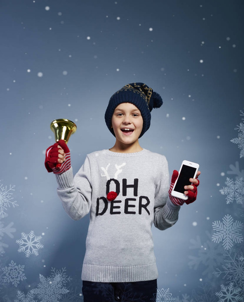 Poika joulun kellon ja matkapuhelimen kanssa
  - Valokuva, kuva