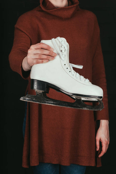 cropped image of woman in holding pair of white skates isolated on black - Photo, Image