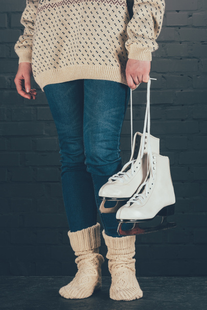 cropped image of woman standing and holding skates with shoelaces - 写真・画像