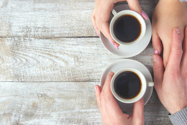 Чашки с кофе в руках мужчин и женщин. Селективный фокус. - Фото, изображение