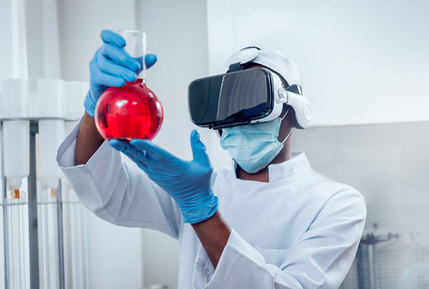 Science technician in virtual reality glasses examines the drug in laboratory.  - Фото, зображення