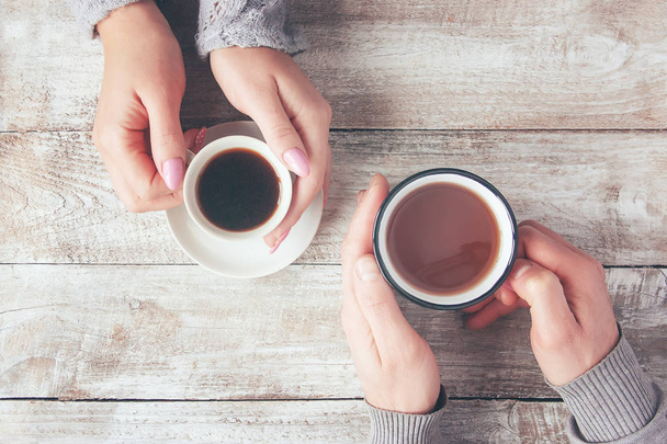Cups of tea in the hands of men and women. Selective focus. - Photo, Image