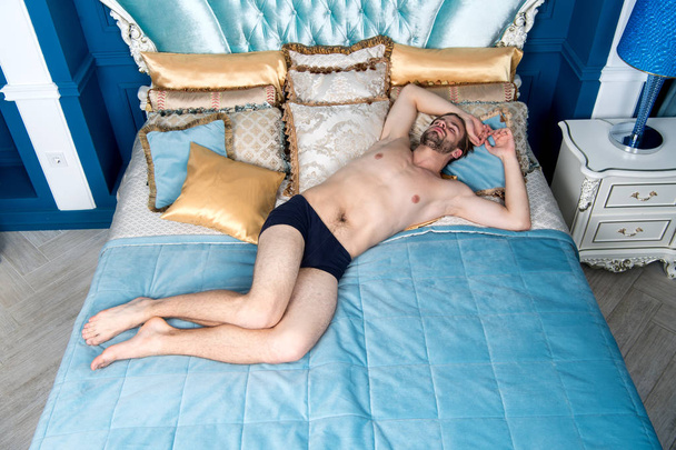 Man sleep in blue bed - Fotoğraf, Görsel