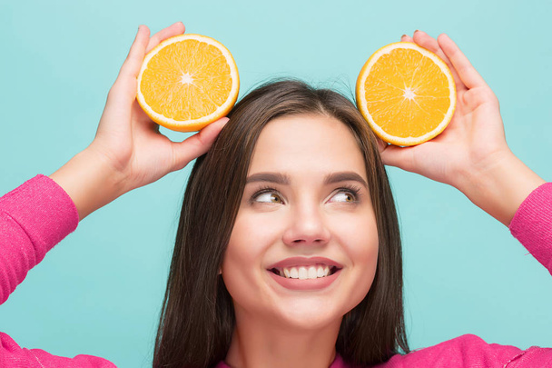 Beautiful womans face with juicy orange - Фото, изображение
