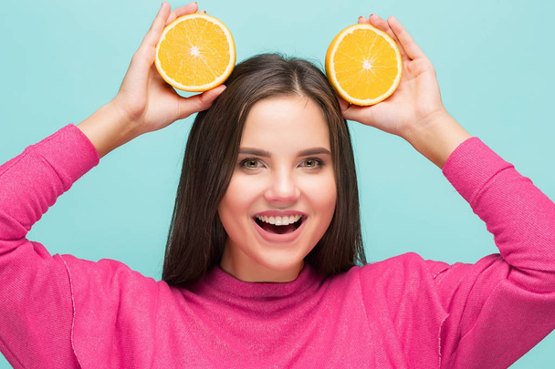 Beautiful womans face with juicy orange - Foto, afbeelding