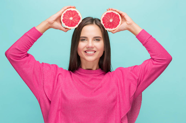 Pretty woman with delicious grapefruit in her arms. - 写真・画像
