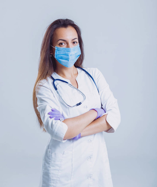 Young nurse or doctor in glasses with stethoscope against white wall - Φωτογραφία, εικόνα