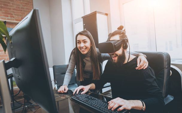 Young man with woman creative office workers testing VR goggles and having fun - Foto, immagini