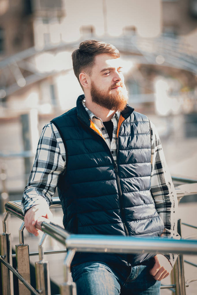 Handsome bearded man in casual clothes posing on camera outdoors - Valokuva, kuva