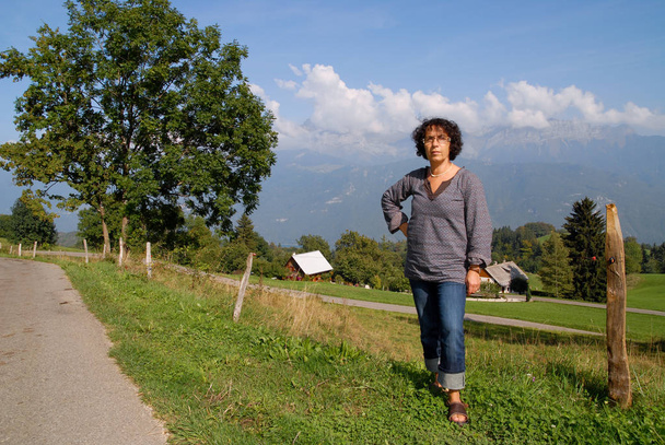 reife brünette Frau, Berge im Hintergrund  - Foto, Bild