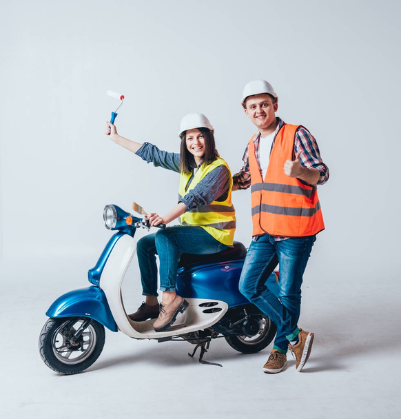 Happy young couple on motorbike with tools. Shopping for construction and repair of new home concept - Фото, изображение