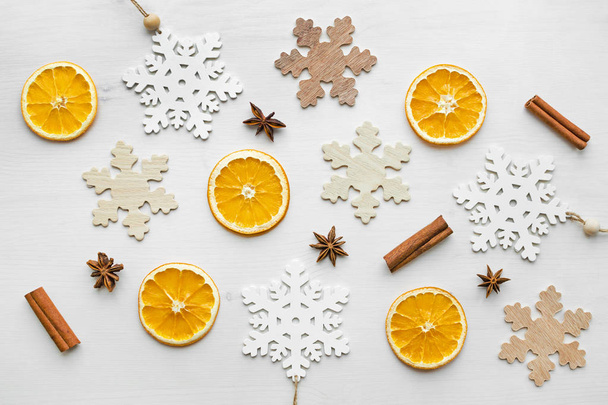 composition with dry oranges, cinnamon sticks, anise stars and wooden snowflakes - Фото, изображение
