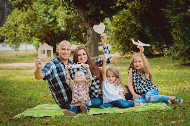 Young family with three children holding advertising signs in park. - Foto, afbeelding