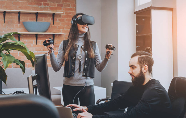 Young man with woman creative office workers testing VR goggles and having fun - Valokuva, kuva