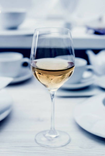 White wine in a glass. Light background - Foto, imagen