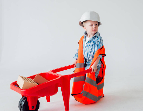 Little boy with wheelbarrow on the white background. Construction, repair, interior. - Foto, immagini