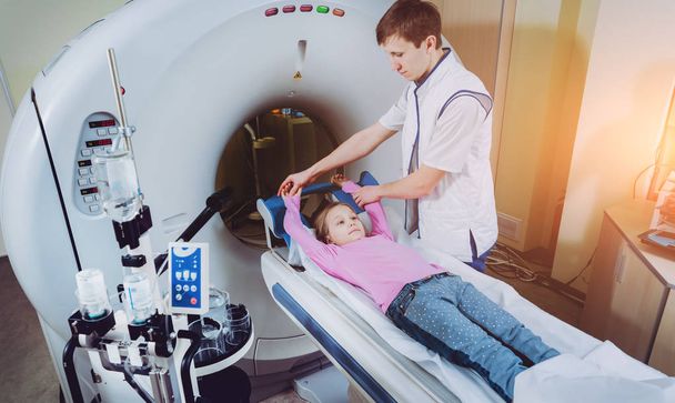 Equipamento médico. Médico caucasiano do sexo masculino e paciente menina em quarto de tomografia computadorizada no hospital
. - Foto, Imagem
