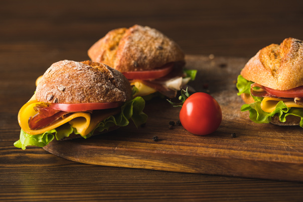 sandwiches with cheese and cherry tomato on cutting board - Fotografie, Obrázek
