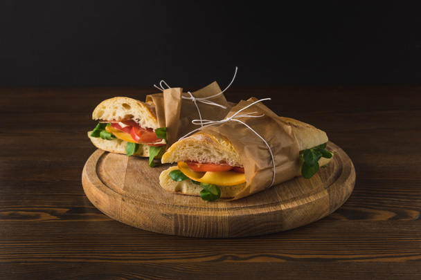 dois panini delicioso cozido com legumes em tábua de madeira
 - Foto, Imagem