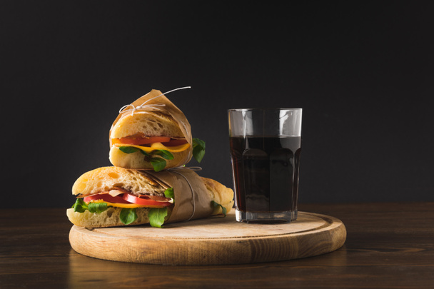 two panini on each other and glass of cola on wooden board  - Zdjęcie, obraz