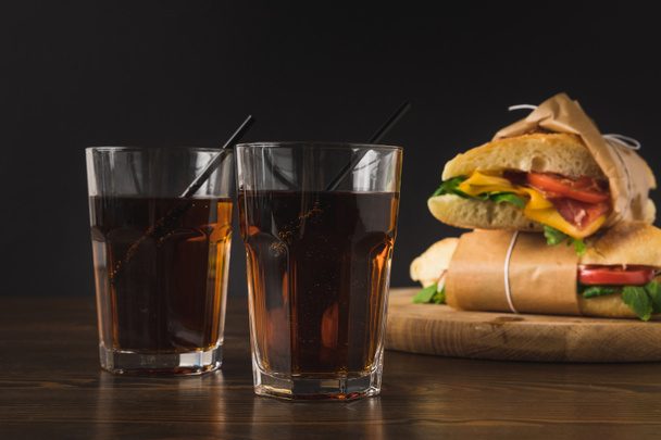 two glasses of cola on table and panini on wooden board - Photo, Image