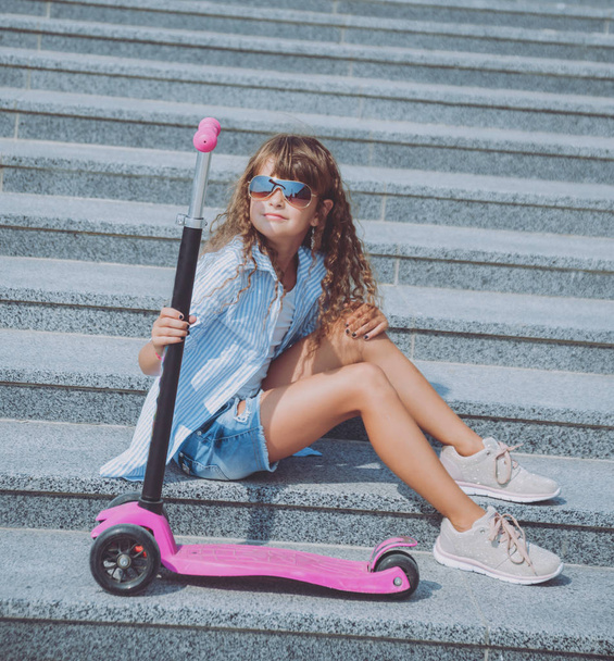 Little girl posing with scooter outdoors - Foto, Bild