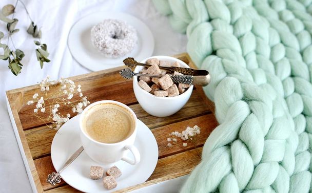 Kopje cappuccino, doughnutt, groene pastel reus plaid, slaapkamer, ochtend concept - Foto, afbeelding