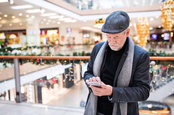 Senior man with smartphone doing Christmas shopping. - Φωτογραφία, εικόνα