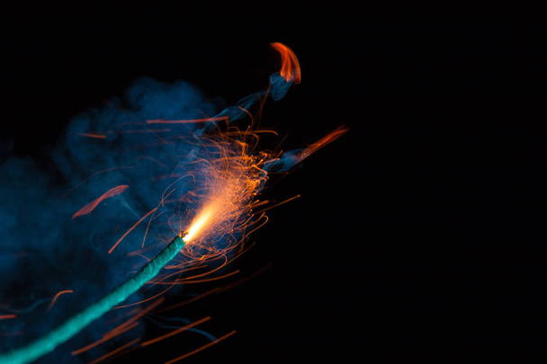 Burning fuse with sparks and blue smoke on black background - Photo, Image