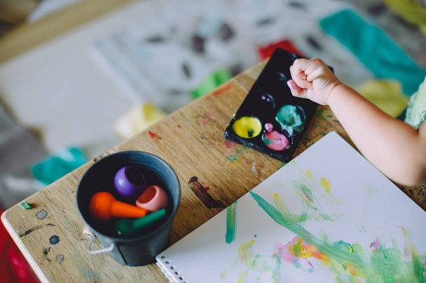 mão de bebê menina desenho com tintas em casa
  - Foto, Imagem