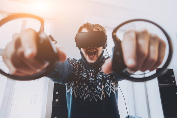 Happy young man plays a game at the office. Virtual reality headset. - Фото, изображение