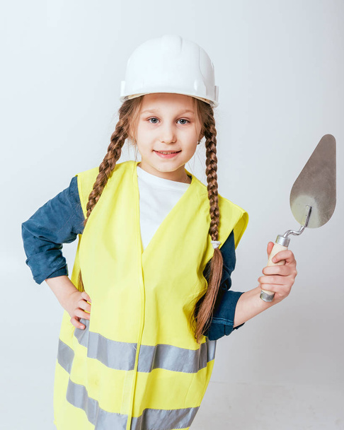 Little cheerful girl with braids playing in repair or construction - Zdjęcie, obraz