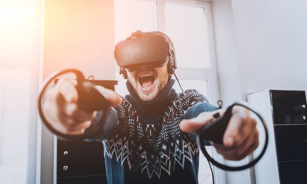 Happy young man plays a game at the office. Virtual reality headset. - Fotografie, Obrázek