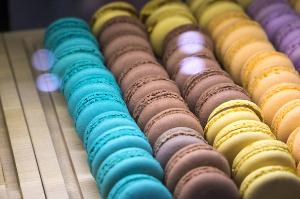 beautiful and tasty multi colored macarons under the shop window of the bakery confectionery shop - Photo, Image