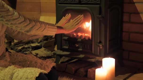 Closeup vrouw opwarming van de aarde zijn handen bij de open haard, gesloten haard Through The Glass - Video