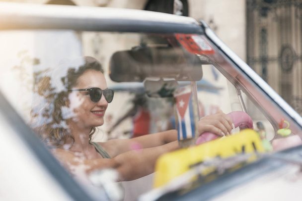 Beautiful woman tourist driving a classic car in Cuba. - Fotoğraf, Görsel