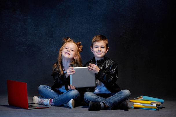 Studio shot of two children with laptop - Φωτογραφία, εικόνα