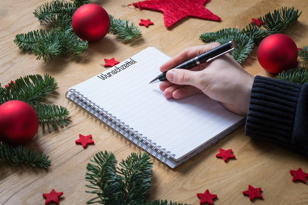 Γράφοντας ένα ευχολόγιο για τα Χριστούγεννα στα Γερμανικά σε ένα σημειωματάριο με Ch - Φωτογραφία, εικόνα