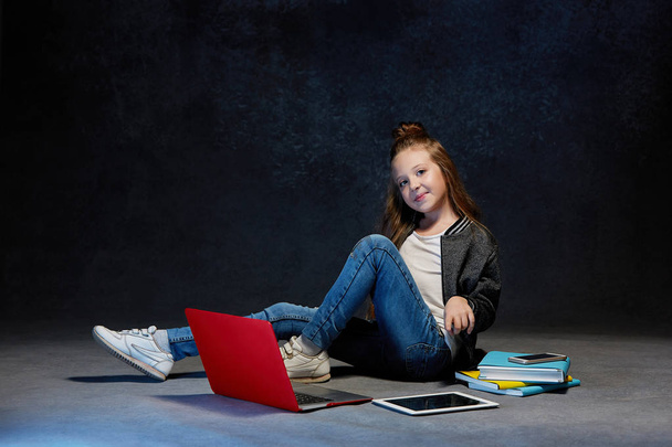 Little girl sitting with gadgets - 写真・画像