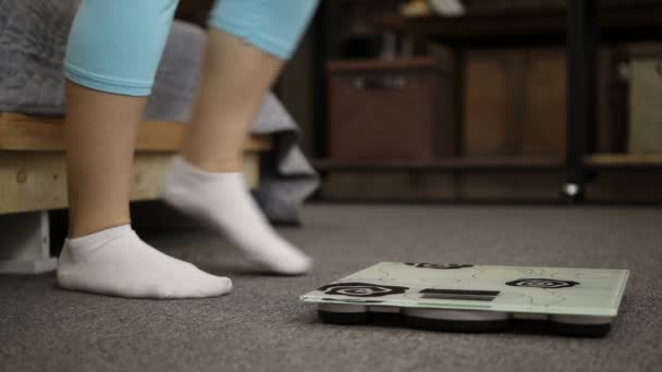 Naisjalat sukissa seisoo painon mittakaavassa
 - Materiaali, video