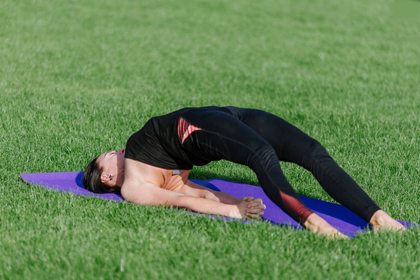 junge Frau macht im Herbst morgens Yoga im Park. - Foto, Bild