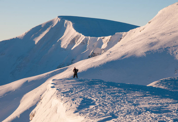 Девушка с сноубордом стоит на вершине горы и любоваться красивыми видами
. - Фото, изображение