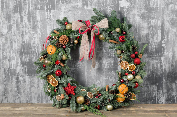 Beautiful Christmas wreath on wooden boards. Preparation for holidays concept. Flower shop is a master work of a professional florist. copy space - Φωτογραφία, εικόνα