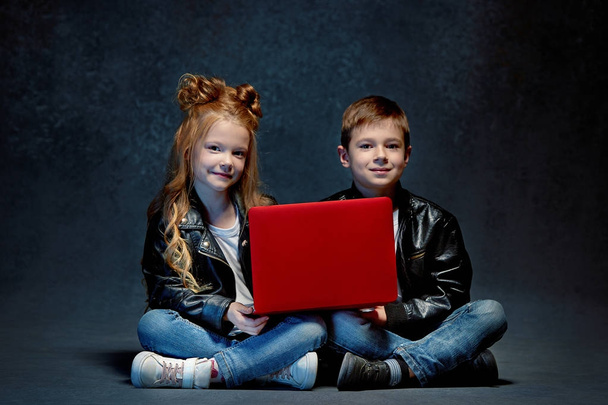 Studio shot of two children with laptop - Fotoğraf, Görsel