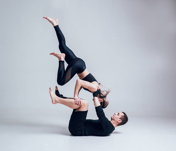 Young caucasian sporty couple posing in studio on white - 写真・画像