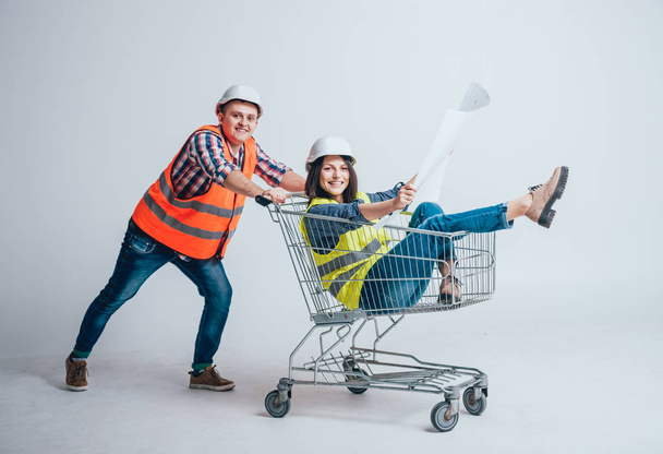 Happy young couple went shopping for construction and repair of new home, concept shot in studio on white - Fotó, kép