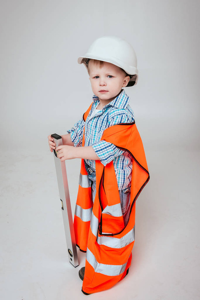 Little boy on the white background. Construction, repair, interior. - Фото, изображение
