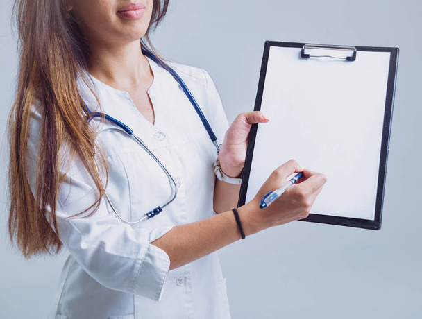 Молодая медсестра или врач в очках со стетоскопом на белой стене
 - Фото, изображение