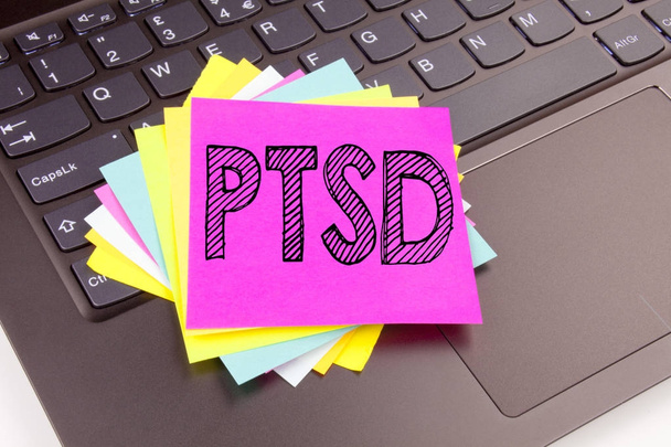 Написання тексту посттравматичного стресового розладу PTSD, зробленого в офісі крупним планом на клавіатурі комп'ютера ноутбука. Бізнес-концепція семінару для лікування здоров'я на чорному тлі з копіювальним простором
 - Фото, зображення