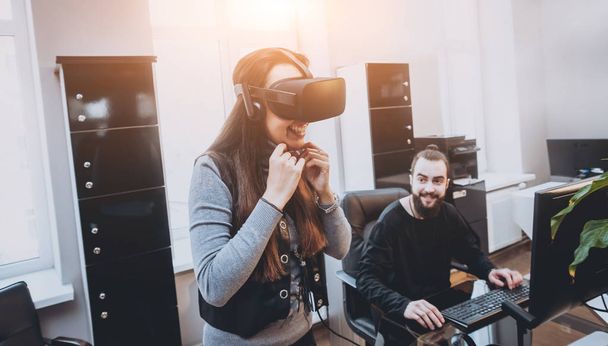 Young man with woman creative office workers testing VR goggles and having fun - Foto, Imagem